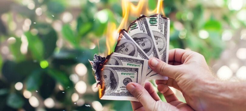 Hands-holding-burning-money